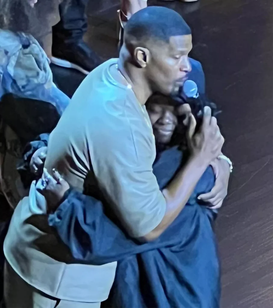 Jamie Foxx hugging a person at his one-man show.